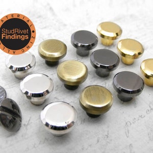 May include: A collection of metal rivets in various finishes, including silver, gold, and black. The rivets have a rounded top and a post for attachment. The image also includes the text "StudRivet Findings".