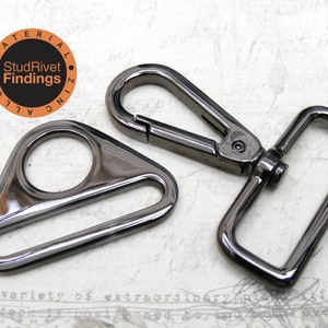 May include: Two black metal hardware pieces for bags or other crafts. The piece on the left is a triangle-shaped D-ring with a round opening. The piece on the right is a rectangular swivel hook with a spring-loaded clasp.