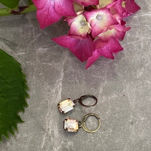 Op de afbeelding: Een set van drie keramische mokken met een gespikkelde, matte afwerking. De mokken zijn in de kleuren crème, lichtgrijs en donkergrijs. Elke mok heeft een eenvoudig, minimalistisch ontwerp en een afgeronde handgreep.