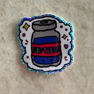Könnte beinhalten: Ein Aufkleber mit einer Cartoon-Illustration eines Glases mit der Aufschrift "PEPTIDES". Das Glas hat einen grauen Deckel, einen blau-roten Körper und eine weiße Umrandung. Der Aufkleber hat einen glitzernden, irisierenden Rand mit Sternen und Herzen.