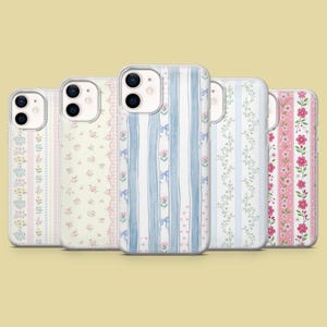 Peut inclure: Cinq coques de téléphone avec des motifs floraux et rayés. Les coques présentent des couleurs pastel, notamment du rose, du bleu et du jaune. Certaines coques ont des rayures verticales avec des nœuds et des fleurs, d'autres des motifs floraux.