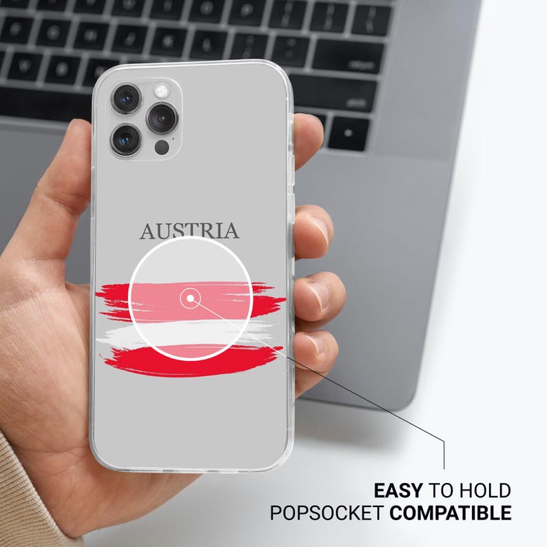 Peut inclure: Une coque de t&eacute;l&eacute;phone transparente avec un design du drapeau autrichien. Le drapeau est rouge, blanc et rouge avec un cercle blanc au centre. Le texte "AUSTRIA" est imprim&eacute; au-dessus du drapeau.