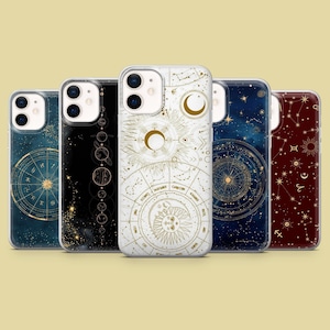 May include: Five phone cases with celestial designs. The cases feature gold and white illustrations of zodiac signs, constellations, and celestial bodies against a dark blue, black, and burgundy background. The cases are made of clear plastic.