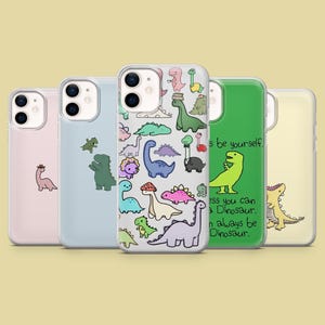 Puede incluir: Cuatro fundas para iPhone diferentes con diseños de dinosaurios. Las fundas son transparentes y muestran el color del teléfono debajo. Una funda tiene un fondo verde con el texto "It's be yourself. Unless you can be a Dinosaur. Then always be a Dinosaur." Otra funda tiene un fondo blanco con un solo dinosaurio en ella. Las otras dos fundas tienen una variedad de dinosaurios coloridos.