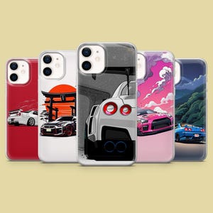 Könnte beinhalten: Vier verschiedene Handyhüllen mit verschiedenen Autodesigns. Die Hüllen sind alle weiß mit durchsichtiger Rückseite und zeigen jeweils ein anderes Autodesign. Die Designs umfassen ein weißes Auto mit rotem Streifen, ein pinkfarbenes Auto mit schwarzem Streifen, ein blaues Auto mit weißem Streifen und ein schwarzes Auto mit weißem Streifen.