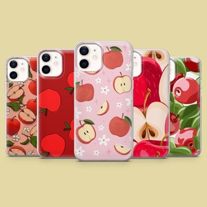 May include: Five different iPhone cases with apple designs. The cases are all clear and show different apple patterns. One case has a red background with white apples, one has a pink background with white flowers and red apples, one has a white background with red apples, one has a white background with red and green apples, and one has a white background with red and green apples.
