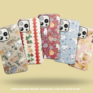 May include: Five phone cases with bunny-themed designs. The cases display rabbits, flowers, and strawberries in beige, red, blue, and pink. The text at the bottom reads "DESIGN SAMPLE PREVIEW. DESIGN MAY VARY BY PHONE MODEL."