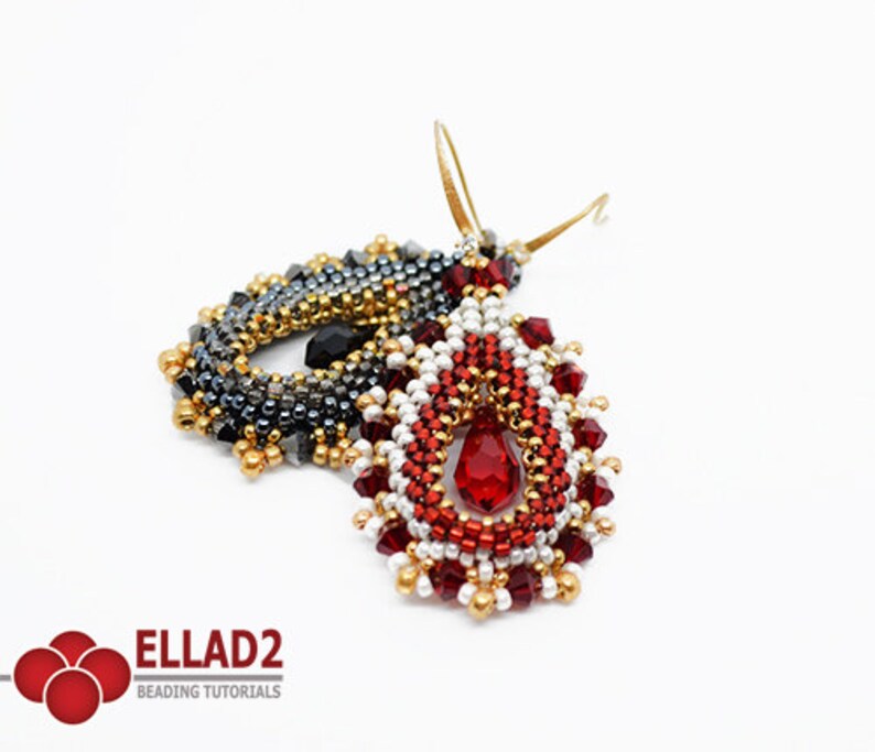 May include: A pair of red, white and gold beaded earrings with a teardrop-shaped design. Each earring features a red crystal in the centre and a gold hook.