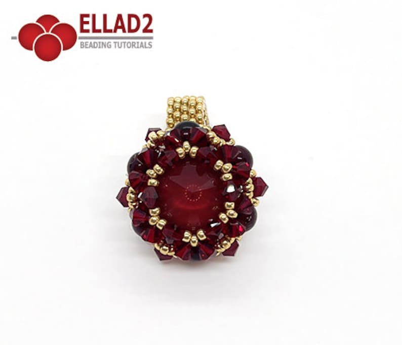 Może przedstawiać: Złoty i czerwony wisiorek z dużymi czerwonymi kamieniami szlachetnymi w środku. Wisiorek jest otoczony mniejszymi czerwonymi i złotymi koralikami.