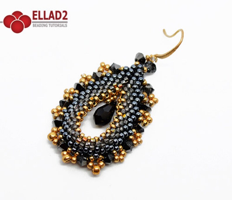 May include: A pair of dangle earrings with a teardrop shape. The earrings are made with black and gold beads and a black crystal.