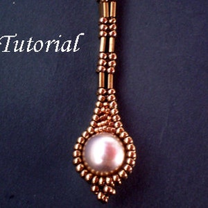 Op de afbeelding: Een gouden kralenhanger met een grote witte parel in het midden. De hanger hangt aan een gouden ketting.