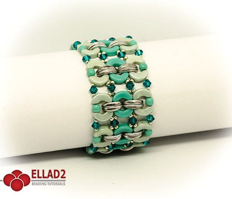 May include: A turquoise and green beaded bracelet with silver accents. The bracelet is made with small round beads and larger, half-round beads.