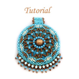 Pode incluir: Um pingente de contas turquesa e cobre com um design de mandala. O pingente tem uma franja de contas ao redor da parte inferior.