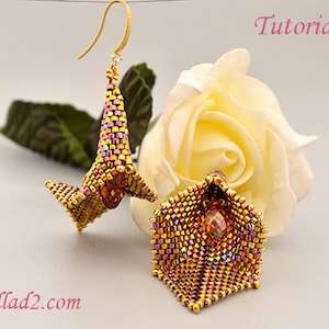 May include: A pair of gold and iridescent beaded earrings shaped like flowers with a crystal in the center. The earrings are hanging from a white rose.