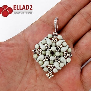 May include: A silver and white beaded pendant with a teardrop shape design. The pendant is hanging from a silver chain.