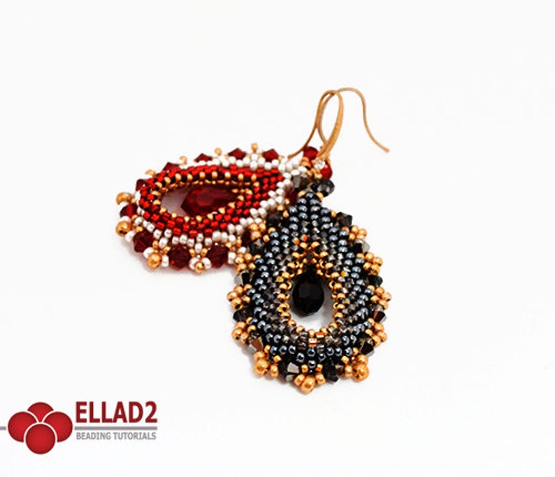 May include: A pair of beaded earrings in a teardrop shape. One earring is red, white, and gold, and the other is black, silver, and gold. Both earrings feature a crystal in the centre.