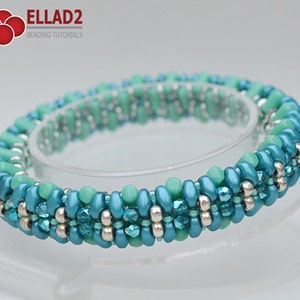 May include: A turquoise and green beaded bracelet with silver beads. The bracelet is made with small seed beads and is woven in a spiral pattern.