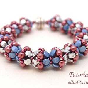 Puede incluir: Un brazalete de cuentas con un cierre plateado. El brazalete está hecho con cuentas azules, plateadas y rosadas en un patrón floral.
