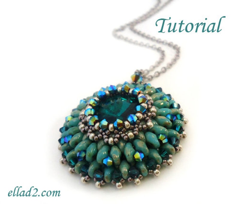 Op de afbeelding: Een teal- en groene kralenketting met een grote smaragdgroene edelsteen in het midden. De hanger is omgeven door kleinere teal- en groene kralen en zilveren kralen. De ketting is aan een zilveren ketting bevestigd. Het woord "Tutorial" staat bovenaan de afbeelding in zwarte tekst.