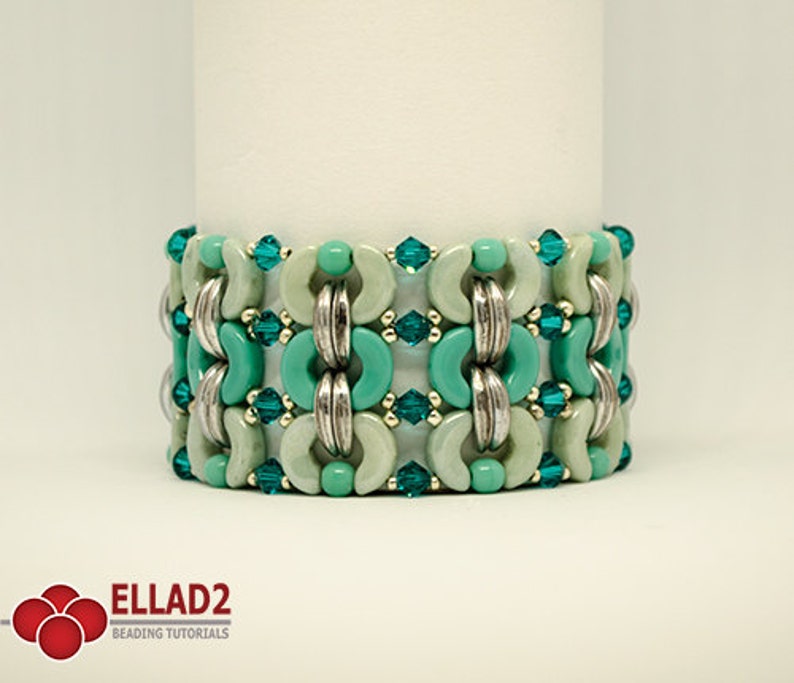 May include: A turquoise and silver beaded bracelet with a geometric pattern. The bracelet is made with round and half-round beads.