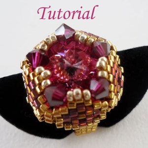 May include: A pink and gold beaded ring with a large pink crystal in the center. The ring is on a black velvet display stand.