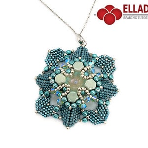 Puede incluir: Un collar con un colgante de cuentas de color verde azulado y plateado con un diseño geométrico. El colgante presenta un diseño central en forma de flor con una piedra verde claro en el centro. El collar está en una cadena de plata.