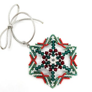 May include: A green, red, and white beaded snowflake ornament with a silver string for hanging.
