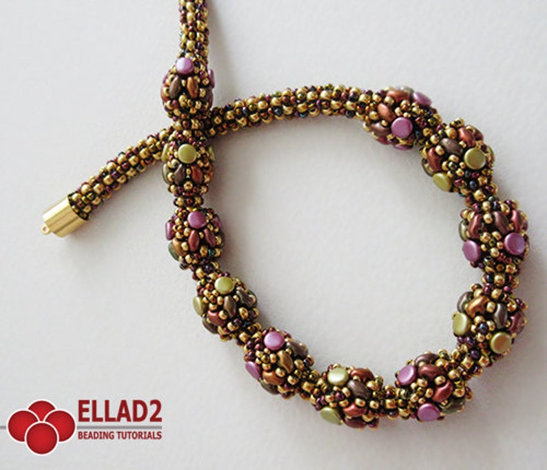 May include: A gold beaded necklace with a series of larger, multi-colored beads. The larger beads are made of smaller beads in shades of brown, green, and purple. The necklace is finished with a gold clasp.