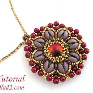 Pode incluir: Um colar de corrente de ouro com um pingente redondo que apresenta um design de flor de contas. A flor é feita com contas roxas, verdes, douradas e vermelhas. O centro da flor tem uma pedra preciosa vermelha e laranja.
