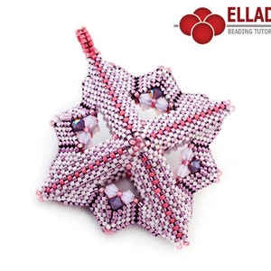 Puede incluir: Un adorno de estrella de color rosa y blanco hecho de cuentas con un lazo para colgar. La estrella está hecha de cuentas pequeñas y tiene un diseño delicado e intrincado.