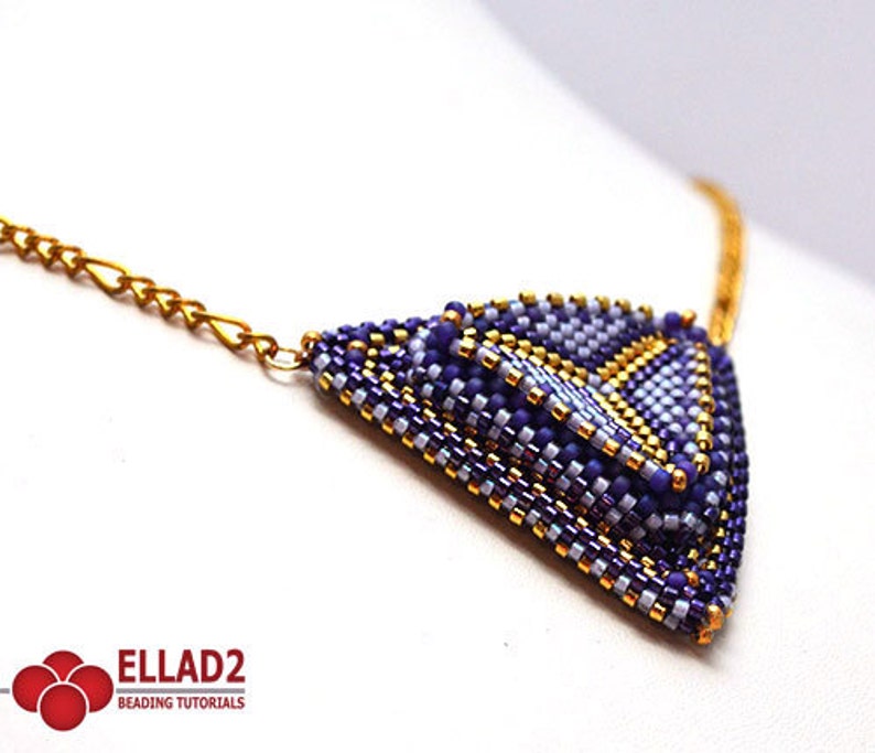May include: A gold chain necklace with a purple and gold beaded triangle pendant.