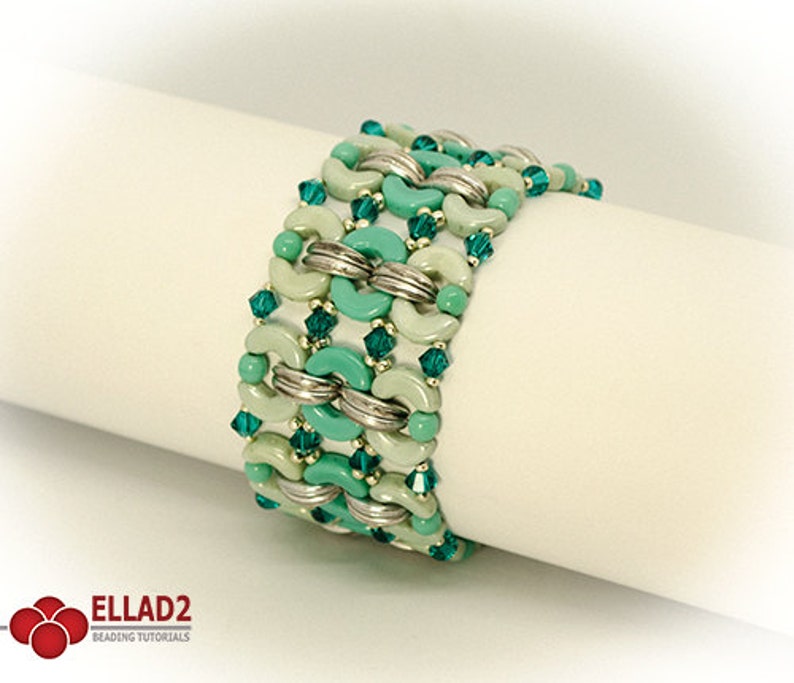 May include: A green and silver beaded bracelet with a geometric pattern. The bracelet is made with small round beads and larger, crescent-shaped beads.