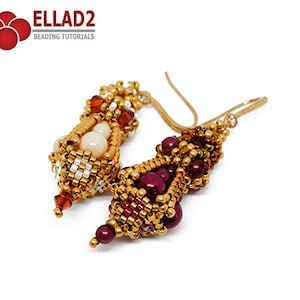 May include: A pair of gold beaded earrings with a burgundy and orange color scheme. The earrings are made with small beads and have a unique, intricate design.