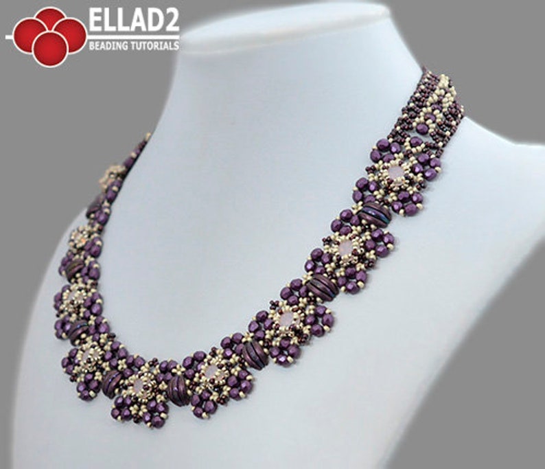 May include: A purple and gold beaded necklace with a geometric design. The necklace features a series of square-shaped beads with a central, light pink bead in each square.