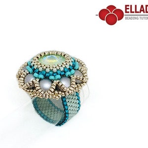 May include: A beaded ring with a large, faceted, light green gemstone in the center. The ring is surrounded by smaller, turquoise and silver beads. The ring is on a white background.
