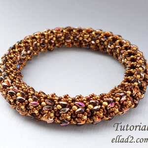 May include: A brown, gold, and iridescent beaded bracelet with a woven pattern. The bracelet is made with small seed beads and larger, flat, iridescent beads.