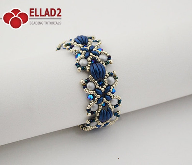 Op de afbeelding: Een blauwe en zilveren kralen armband met een bloemenmotief. De armband is gemaakt van kleine, ronde kralen en heeft een delicate, vrouwelijke uitstraling.