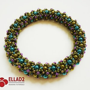 Op de afbeelding: Een geweven armband van groene, paarse en blauwe kralen.