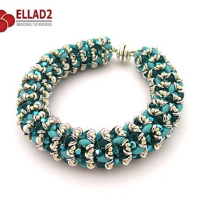 以下が含まれることがあります： ターコイズとシルバーのビーズブレスレットで、マグネット式の留め具が付いています。ブレスレットは、小さな丸いビーズで作られており、螺旋状のデザインになっています。