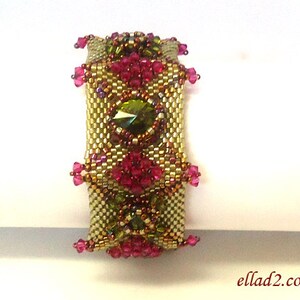 May include: A gold and green beaded bracelet with pink and purple accents. The bracelet features a large green gemstone in the center.