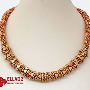 Puede incluir: Un collar de cuentas doradas y coral con un patrón geométrico. El collar está hecho con pequeñas cuentas de semillas y presenta un diseño de triángulo repetido.