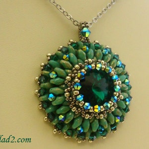 Op de afbeelding: Een groene en zilveren kralenketting met een grote smaragdgroene edelsteen in het midden. De hanger is omringd door kleinere groene en zilveren kralen.