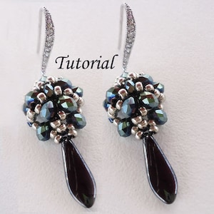 May include: A pair of silver dangle earrings with black teardrop-shaped beads and a cluster of dark blue and silver beads at the top. The earrings are labeled "Tutorial".