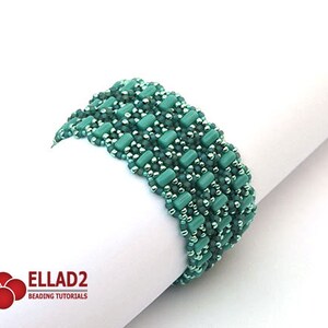 Op de afbeelding: Een groene kralen armband met een geweven patroon. De armband is gemaakt met kleine, ronde kralen en grotere, rechthoekige kralen.