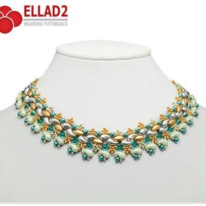 Peut inclure: Un collier de perles argentées, dorées et turquoise avec un motif géométrique. Le collier est sur un buste de mannequin blanc.