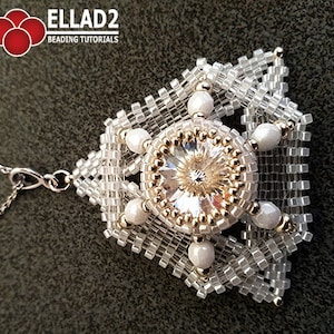 May include: A white beaded pendant with a clear crystal in the centre, surrounded by smaller white beads. The pendant is attached to a silver chain.
