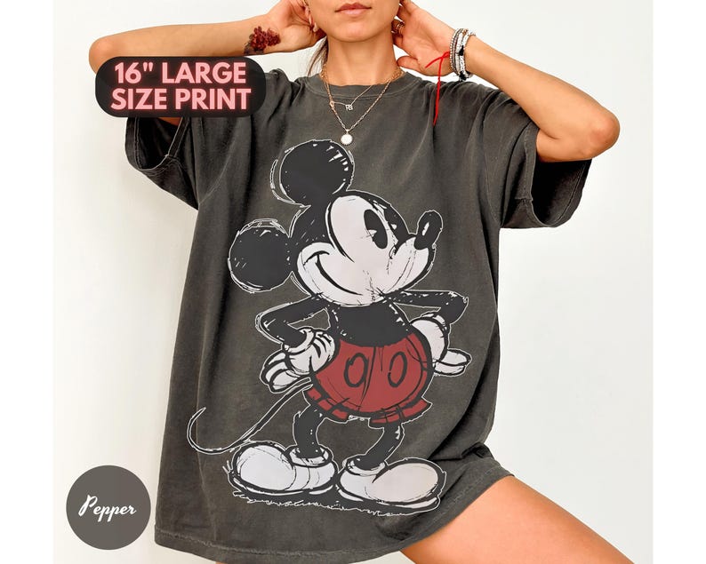 Puede incluir: Camiseta gris oscuro con un gran gr&aacute;fico de Mickey Mouse. El dise&ntilde;o incluye un contorno negro y pantalones cortos rojos. El texto "16" LARGE SIZE PRINT" es visible. La camiseta tiene un aspecto vintage y desgastado.