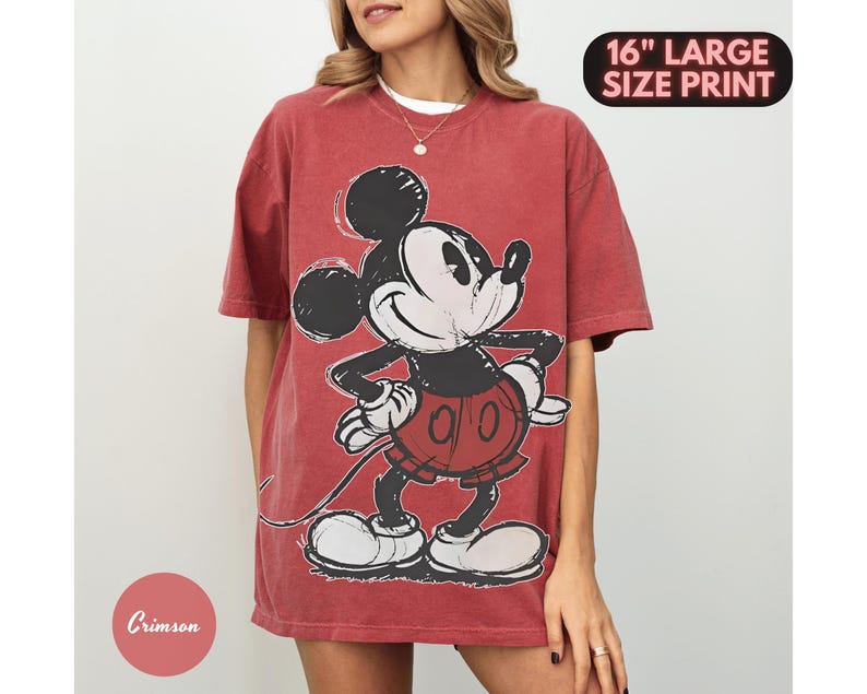 Puede incluir: Camiseta de color rojo carmes&iacute; con un gran gr&aacute;fico de Mickey Mouse. El personaje de dibujos animados est&aacute; representado en negro, blanco y rojo. La camiseta tiene un aspecto desgastado y el texto "16" LARGE SIZE PRINT" es visible.