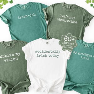 K&ouml;nnte beinhalten: Eine Auswahl an gr&uuml;nen und wei&szlig;en T-Shirts mit humorvollen Spr&uuml;chen zum St. Patrick's Day. Die Shirts zeigen S&auml;tze wie "irish-ish", "let's get shamrocked" und "accidentally irish today".