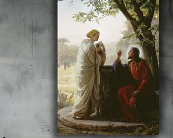 May include: A framed canvas print of a religious scene. The artwork depicts two figures near a well, one in a white robe and the other in a red robe. The background shows a landscape with trees and a field. The print is displayed above a bed.